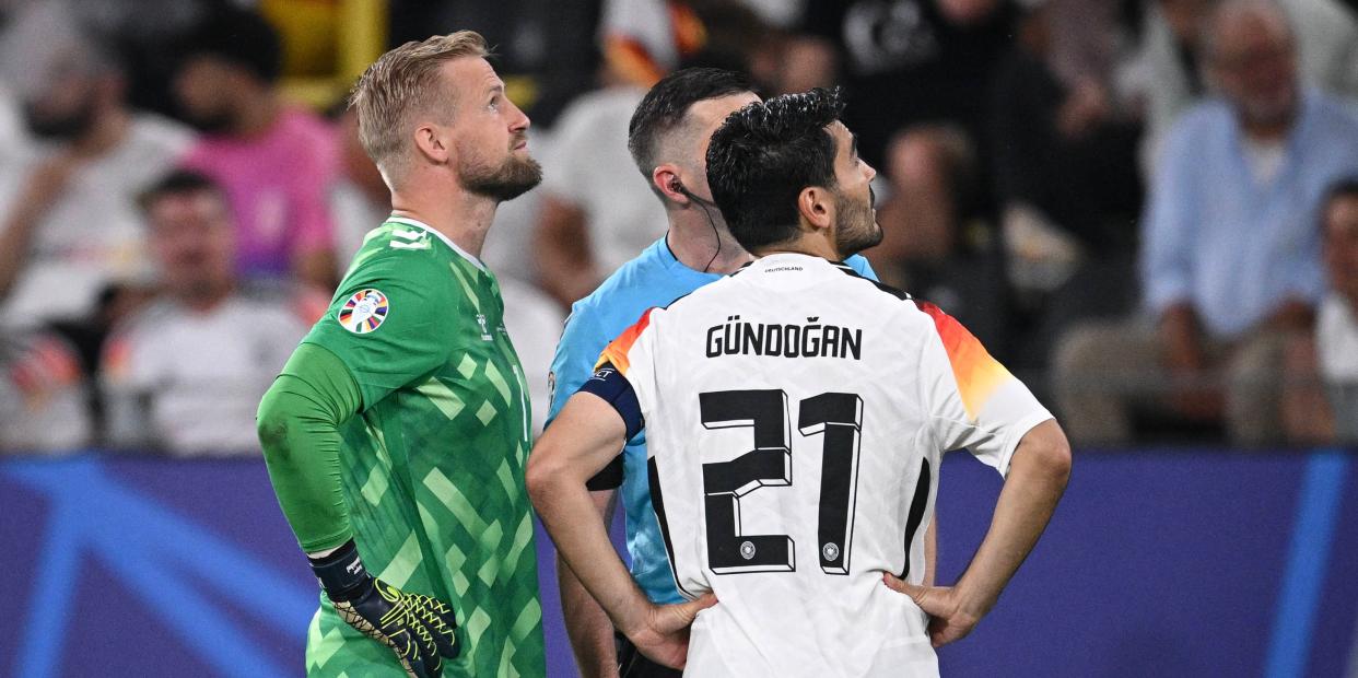 Michael Oliver (m.) erklärte Kasper Schmeichel und Ilkay Gündogan vor Wiederanpfiff die Situation.<span class="copyright">IMAGO/Ulmer/Teamfoto</span>