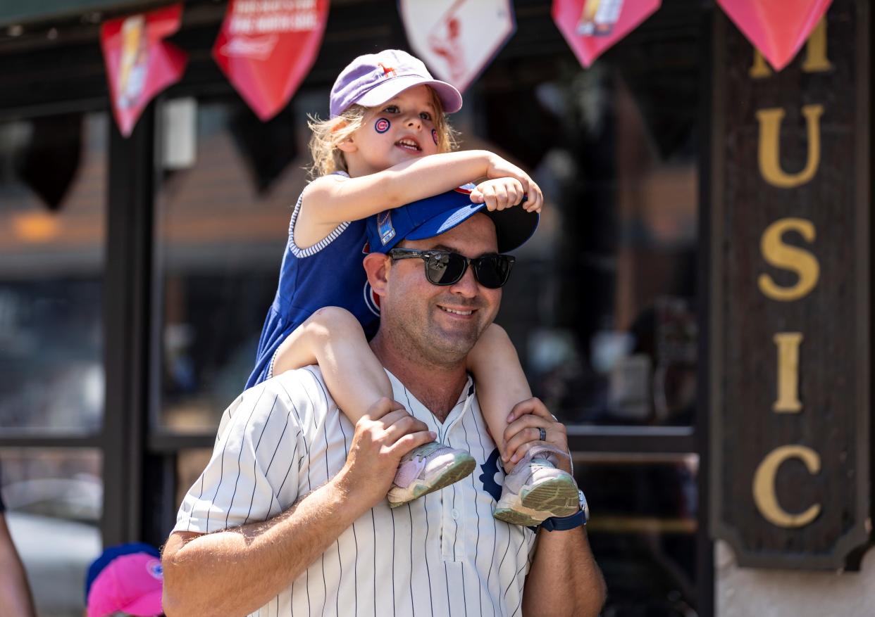 A man carrying a girl on his shoulders goes to a Chicago Cubs' game in Chicago on June 11, 2021, where masks are required for unvaccinated individuals amid Delta variant concerns. (Photo by Joel Lerner/Xinhua via Getty Images)