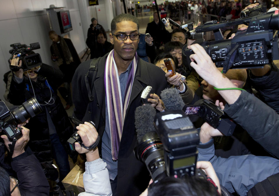 Former NBA basketball star Charles D. Smith, center, is mobbed by journalists upon arrival at the Beijing Capital International Airport in Beijing from Pyongyang, North Korea, Friday, Jan. 10, 2014. A squad of former basketball stars led by Dennis Rodman had a friendly game with North Korean basketball players in Pyongyang. (AP Photo/Andy Wong)