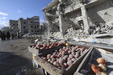 Produce are covered in dust as people inspect a site hit by what activists said were airstrikes carried out by the Russian air force on a busy market place in the town of Ariha, in Idlib province, Syria in this November 29, 2015 file photo. REUTERS/Ammar Abdullah