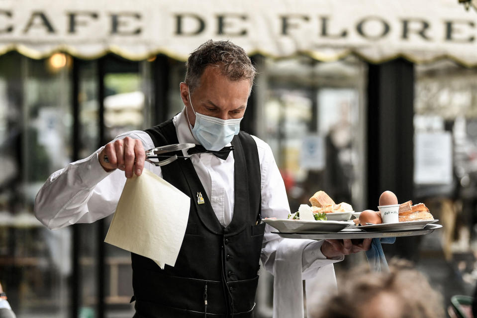 Image: A waiter works at the terrace of Paris' landmark Cafe de Flore (Bertrand Guay / AFP - Getty Images)