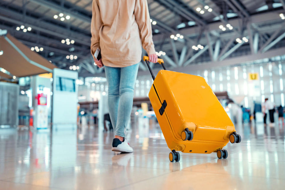 person rolling a suitcase in the airport