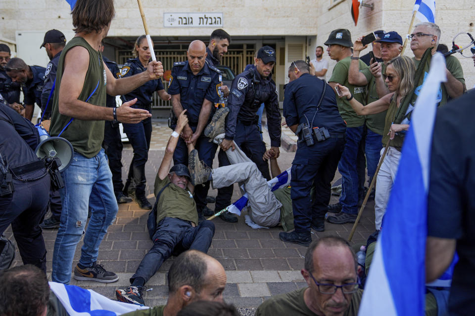 Israeli police disperse demonstrators, mostly military reservists, who block a road outside the house of Israeli Justice Minister Yariv Levin during a protest against plans by Prime Minister Benjamin Netanyahu's government to overhaul the judicial system, in Modiin, Israel, Monday, Sept. 11, 2023. (AP Photo/Ohad Zwigenberg)