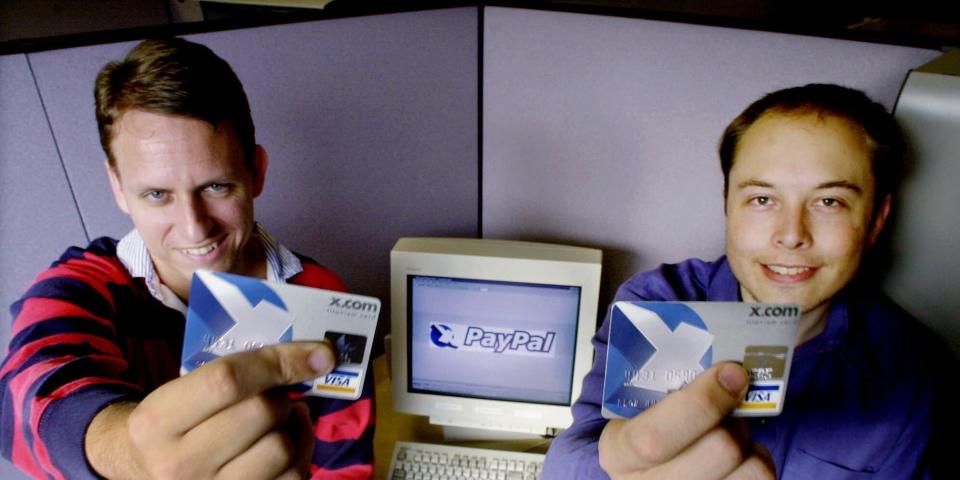 Peter Thiel, links, und Elon Musk, rechts, halten am 20. Oktober 2000 VISA-Kreditkarten mit dem Firmenlogo von X.com in der Hand. - Copyright: Paul Sakuma/AP