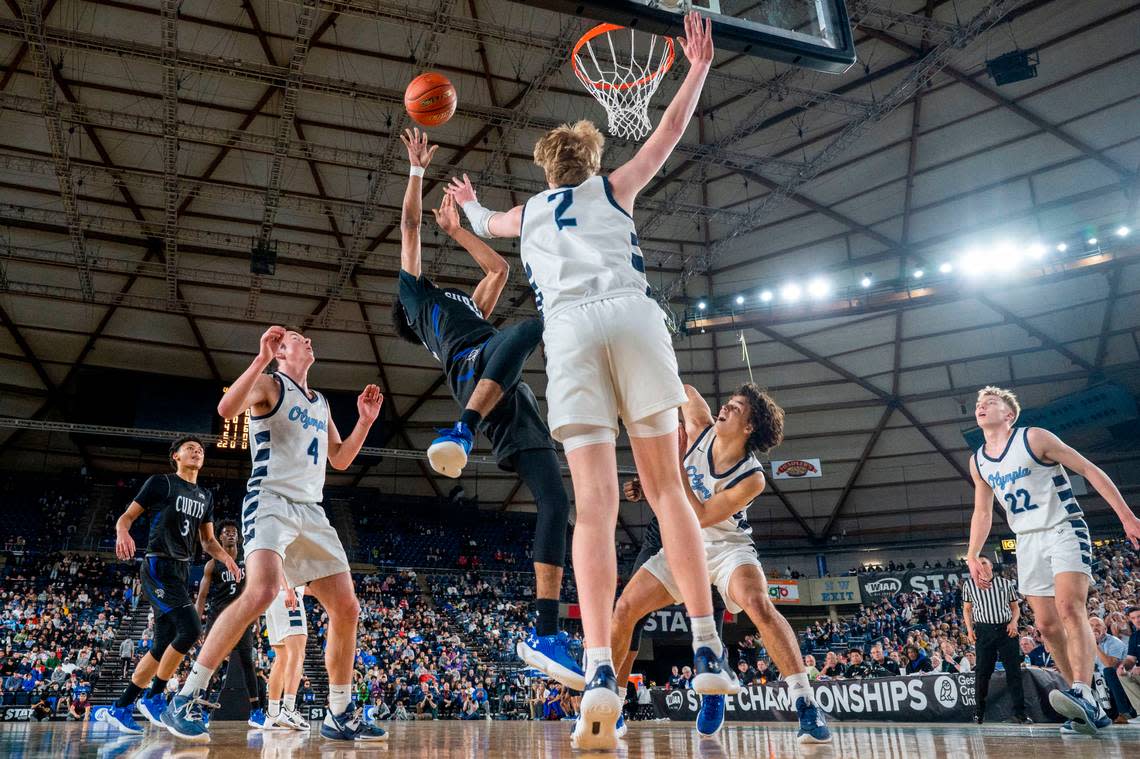 Curtis guard Cinque Maxwell (12) attempts a fall-away shot as Olympia forward Andreas Engholm (2) defends during the first quarter of the Class 4A championship game on Saturday, March 4, 2023, in Tacoma, Wash.