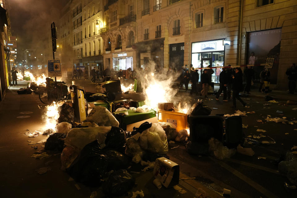 ARCHIVO - Manifestantes prenden fuego a pilas de basura sin recoger en una protesta cerca de la Plaza de la Concordia, en París, el 16 de marzo de 2023. (AP Foto/Lewis Joly, Archivo)