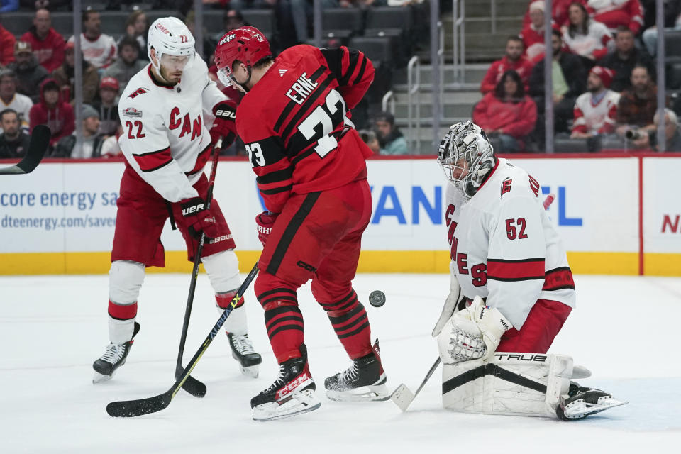 Detroit Red Wings left wing Adam Erne (73) tries to redirect a shot on Carolina Hurricanes goaltender Pyotr Kochetkov (52) as Brett Pesce (22) defends in the second period of an NHL hockey game Tuesday, Dec. 13, 2022, in Detroit. (AP Photo/Paul Sancya)