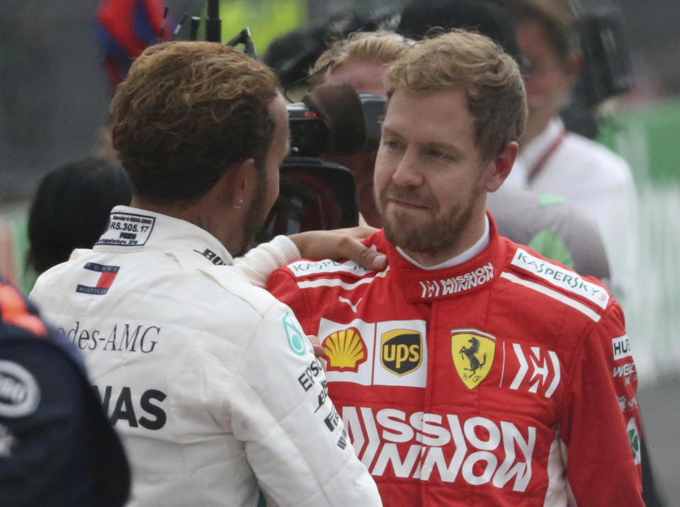 Mercedes driver Lewis Hamilton, of Britain, left, is congratulated by Ferrari driver Sebastian Vettel, of Germany, after Hamilton became Formula One champion in the Mexico Grand Prix auto race at the Hermanos Rodriguez racetrack in Mexico City, Sunday, Oct. 28, 2018. (AP Photo/Tomas Stargardter)