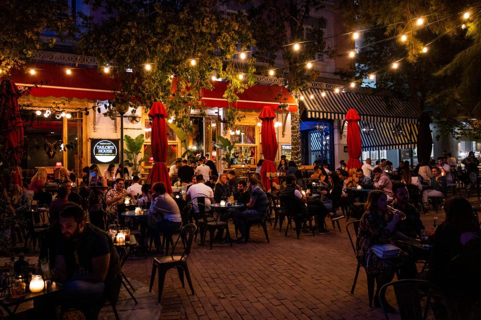 People in a restaurant in Greece with string lights outside