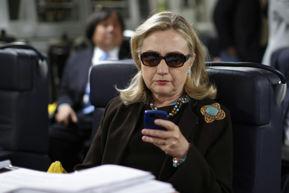 FILE - Then-Secretary of State Hillary Clinton checks her Blackberry from a desk inside a C-17 military plane upon her departure from Malta, in the Mediterranean Sea, bound for Tripoli, Libya, on Oct. 18, 2011. For years, problems with classified materials have been a shortcut to controversy in Washington. (AP Photo/Kevin Lamarque, Pool, File)