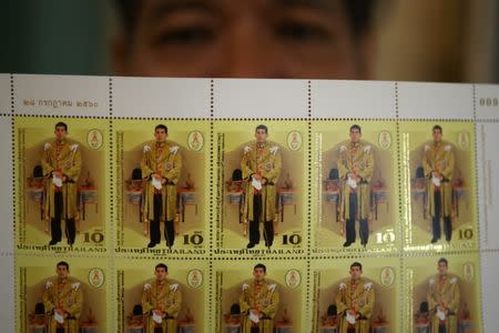 A man poses after buying mail stamps printed as part of celebrations for the 65th birthday of Thai King Maha Vajiralongkorn in Bangkok, Thailand, July 28, 2017. REUTERS/Athit Perawongmetha