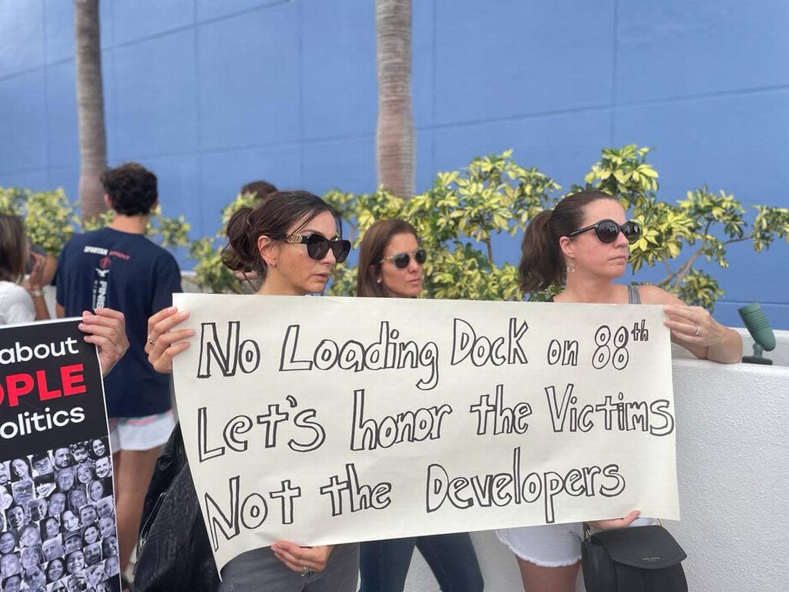 Women opposed to having the access of the condo’s loading dock on 88th Street hold a banner outside Surfside’s town hall on Wednesday, Sept. 27, 2023 “Let honor the victims, not the developers,” the sign read.