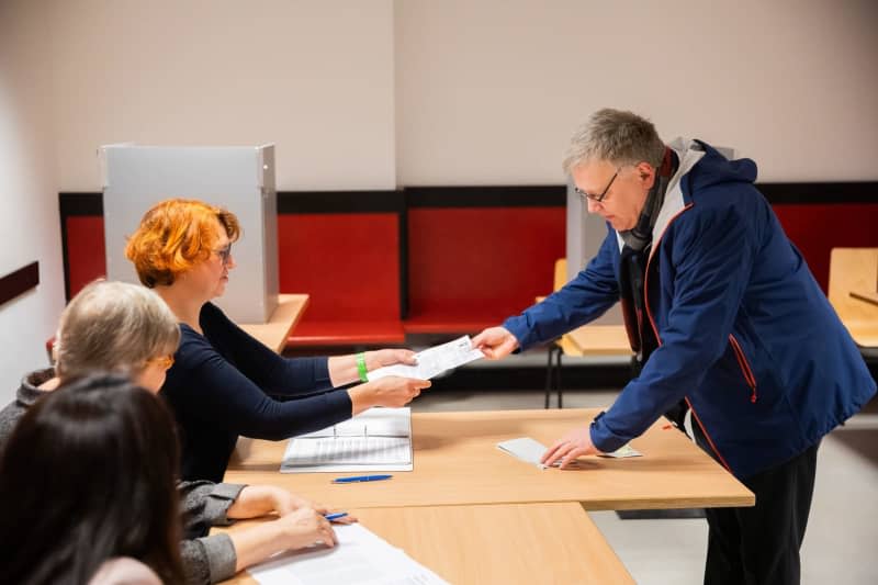 Stephan Bröchler (r), state returning officer for Berlin, votes at the polling station in the Carl-von-Ossietzky-Gymnasium in Berlin-Pankow. Voters in hundreds of Berlin constituencies head to the polls for a partial re-run of the 2021 federal election, after numerous mishaps the first time round. Christoph Soeder/dpa