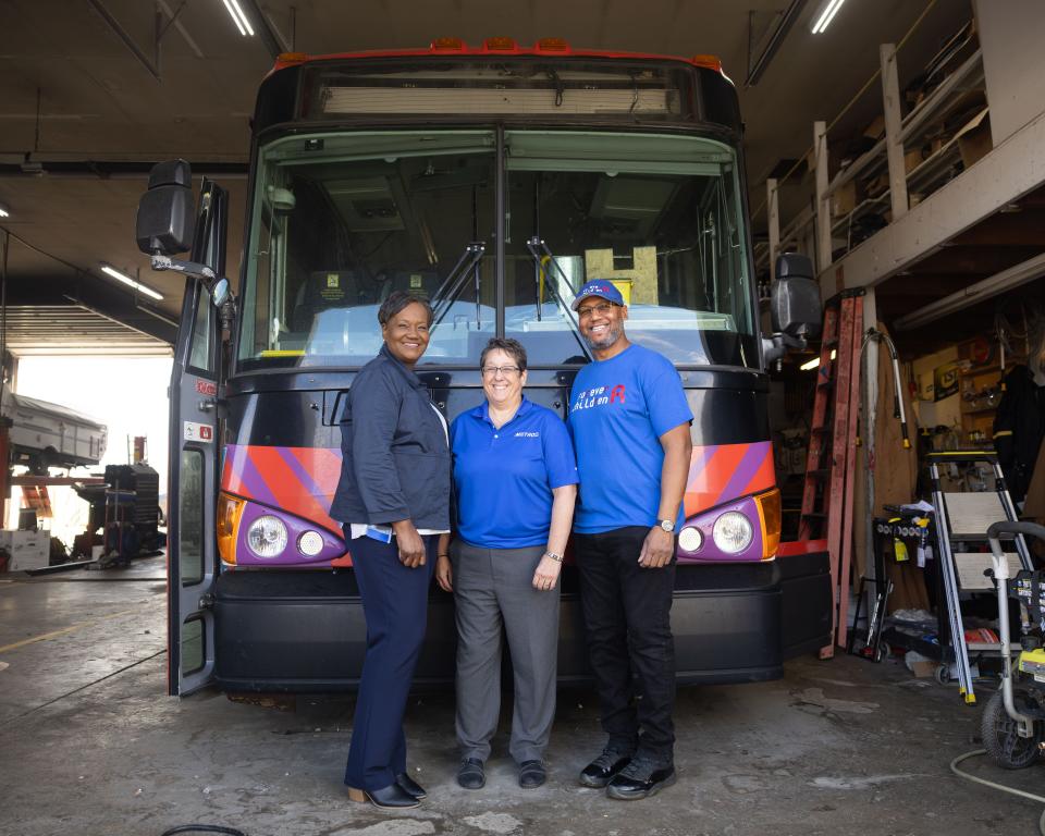 Lori Porter of Love Akron, left, Akron Metro RTA CEO Dawn Distler and Forever R Children founder Robert Ford stand in front of the former Metro bus that is being converted into a mobile shower facility.