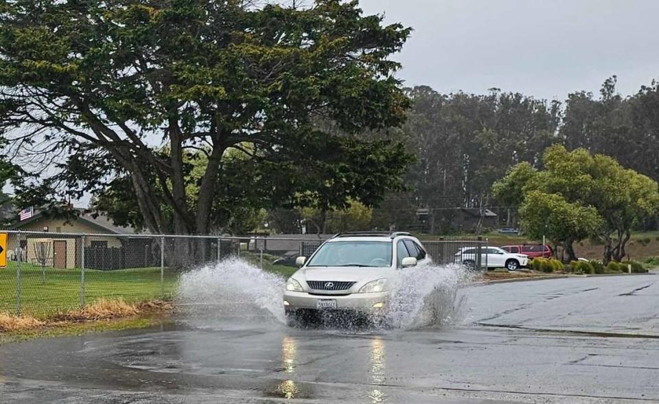 A car drives through puddles on Howard Street in Los Osos as a “vigorous storm” lingers over San Luis Obispo County on March 29, 2024.