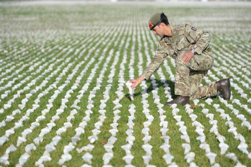 Captain James Pugh places a figure among artist Rob Heard’s installation Shrouds of the Somme at the Queen Elizabeth Olympic Park in London (Kirsty O’Connor/PA)