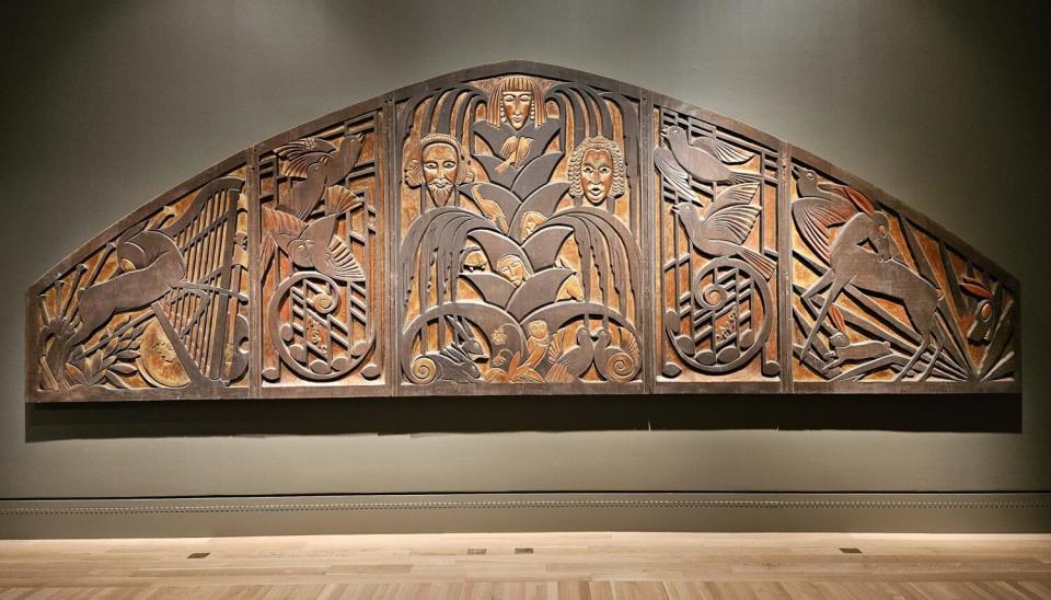 A carved proscenium relief with stylized images of a tree of life.