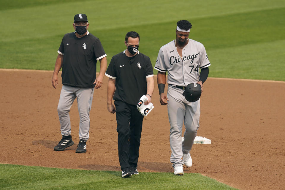 CORRECTS TO THIRD INNING NOT SECOND INNING Chicago White Sox's Eloy Jimenez, right, leaves the game with an injury next to a trainer and manager Rick Renteria, left, during the third inning of Game 3 of an American League wild-card baseball series against the Oakland Athletics, Thursday, Oct. 1, 2020, in Oakland, Calif. (AP Photo/Eric Risberg)