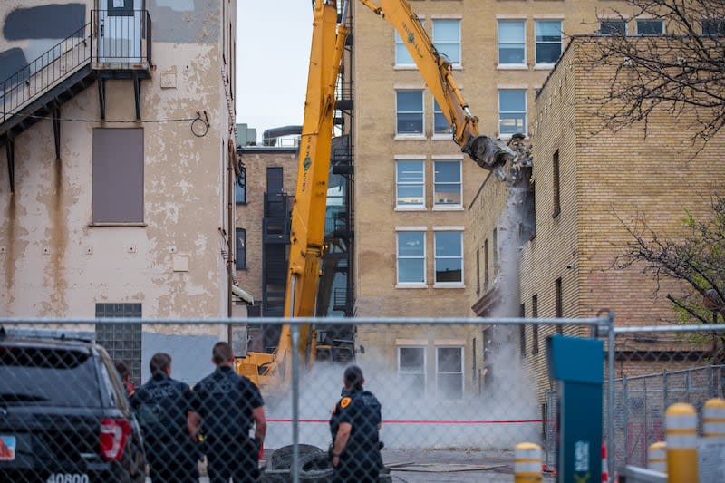 Salt Lake City police guarding the perimeter of the Utah Pantages Theater watch as demolition crews knock down an old parking garage next to the theater on April 19, 2022. | Carter Williams, KSL.com