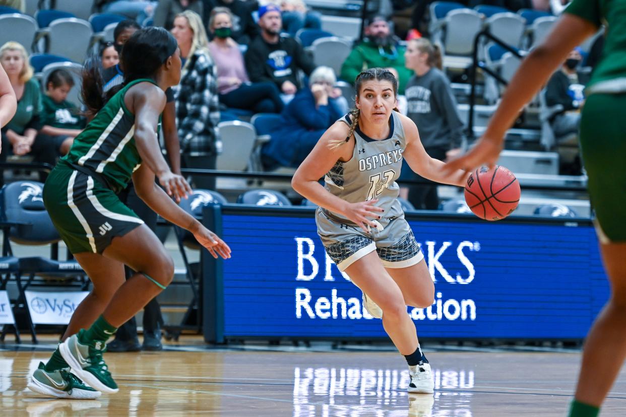 Rhetta Moore of the University of North Florida drives against Jacksonville's Taylor Hawks during Saturday's ASUN women's basketball game at UNF Arena.