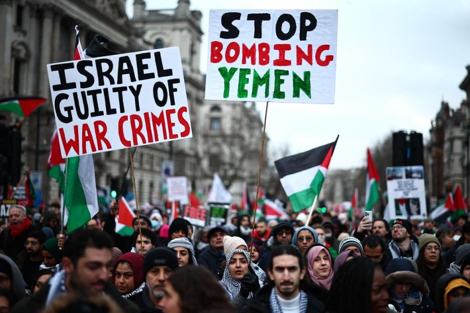 Pro-Palestinian demonstrators in London including one carrying a sign protesting the bombing in Yemen (AFP via Getty Images)