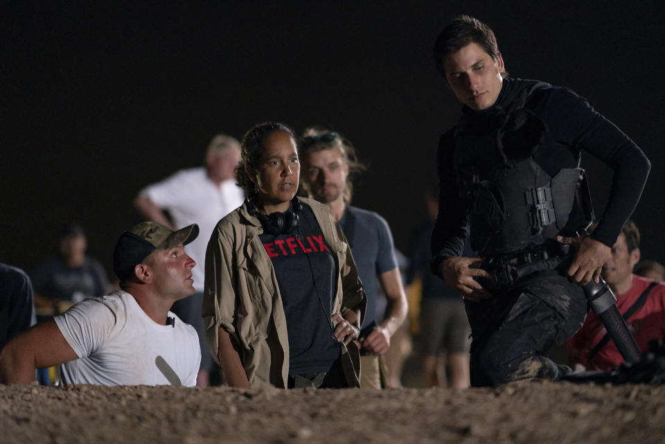 En esta imagen proporcionada por Netflix la directora Gina Prince-Bythewood, centro, con el actor Luca Marinelli, derecha, durante la filmación de "The Old Guard". La película de acción protagonizada por Charlize Theron y KiKi Layne se estrena el 10 de julio en Netflix. (Aimee Spinks/Netflix via AP)