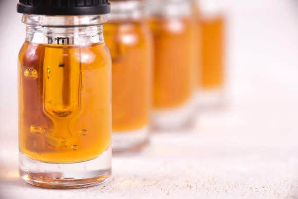 Four vials of hemp-based cannabidiol oil lined up on a counter.