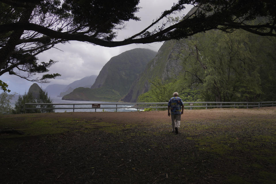 The Rev. Patrick Killilea walks toward cliffs of Kalaupapa, Hawaii, on Tuesday, July 18, 2023. Banishing the sick to the isolated Kalaupapa settlement was once the government's answer to a deadly leprosy outbreak in the 1800s that persisted into the next century. (AP Photo/Jessie Wardarski)
