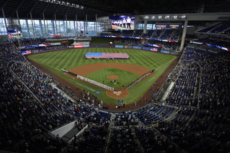 FILE - Fans and players stand for the national anthem before the start of a baseball game between the Miami Marlins and the Pittsburgh Pirates, Thursday, March 28, 2024, in Miami. The city of Miami will host the World Baseball Classic championship game again in March 2026, concluding a tournament that also will be played in Houston, Tokyo and San Juan, Puerto Rico. (AP Photo/Wilfredo Lee, File)