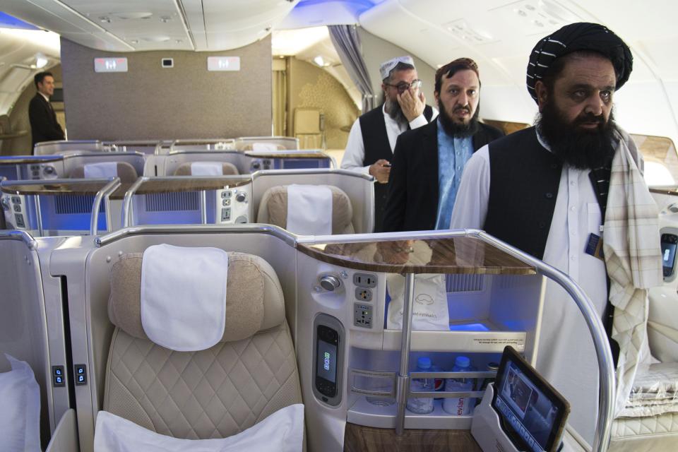 Afghan Taliban Envoy to the United Arab Emirates Badruddin Haqqani, far right, walks through an Emirates A380's business class on display at the Dubai Air Show in Dubai, United Arab Emirates, Monday, Nov. 13, 2023. The biennial Dubai Air Show opened Monday as airlines are poised to make major aircraft purchases after rebounding from the groundings of the coronavirus pandemic, even as Israel's war with Hamas clouds regional security. (AP Photo/Jon Gambrell)