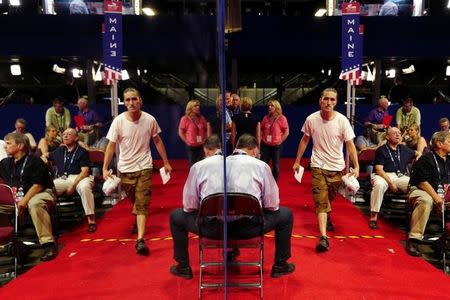 People are reflected on a mirrored wall on the floor of the Republican National Convention in Cleveland, Ohio, U.S. July 16, 2016. REUTERS/Mark Kauzlarich