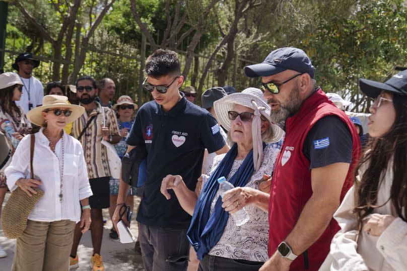 Einer Touristin wird von Sanitätern der antiken Akropolis im Zentrum Athens geholfen, Mittwoch, 12. Juni 2024. 