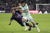 Orlando City defender Kyle Smith, left, takes the ball from Atlanta United midfielder Thiago Almada (23) during the second half of an MLS soccer match, Saturday, May 27, 2023, in Orlando, Fla. (AP Photo/John Raoux)