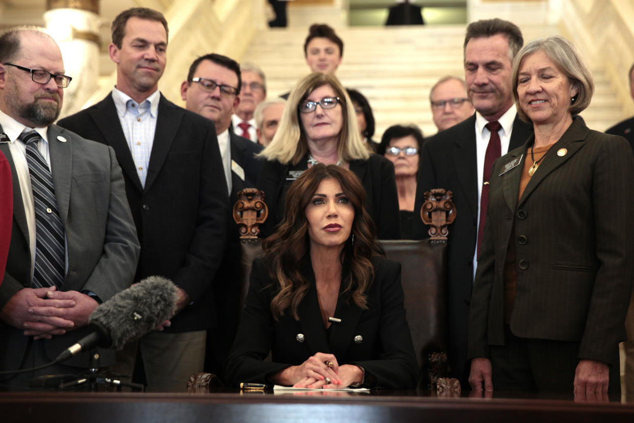 FILE - South Dakota Gov. Kristi Noem signs a bill Feb. 3, 2022, at the state Capitol in Pierre, S.D., that will ban transgender women and girls from playing in school sports leagues that match their gender identity. Noem's election-year fight with fellow Republicans in the Legislature has spurred criticism she is neglecting her job to angle for the White House. (AP Photo/Stephen Groves, File)