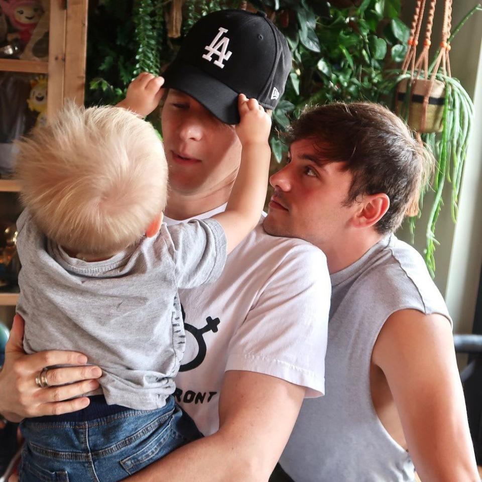 Tom Daley and Dustin Lance Black carry their toddler son Robbie