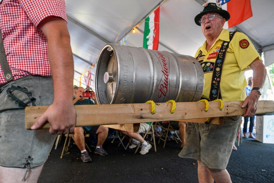 Volksfest Co-Chairman Robert Wright, left, and Tom Memmer carry a keg through the crowd for the ceremonial keg tap to kick off the first night of Volksfest at the Germania Maennerchor in Evansville, Ind., Thursday, Aug. 5, 2021. The three day celebration offers visitors German food, beer, music and culture from 11 a.m. to midnight until Saturday, Aug. 7.