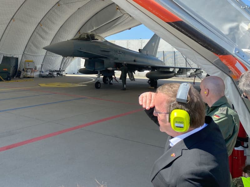 Boris Pistorius (L), Germany's Defence Minister, and Swen Jacob, lieutenant colonel and German contingent commander, look at a hangar with an air force Eurofighter. Alexander Welscher/dpa