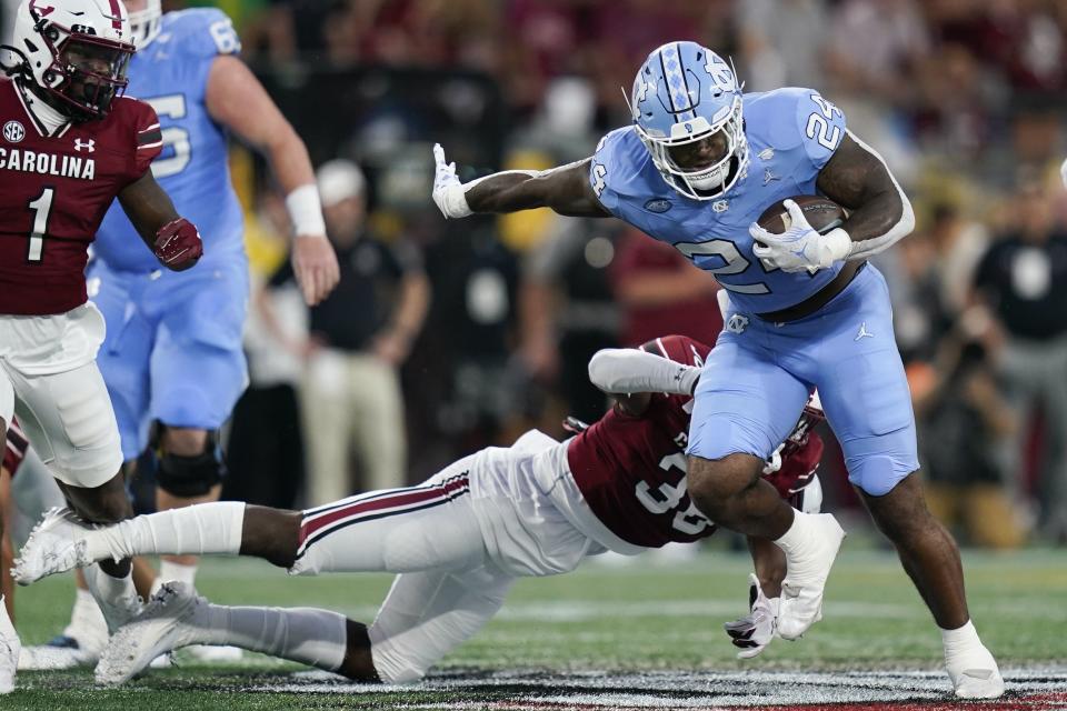 North Carolina running back British Brooks, right, is tackled by South Carolina defensive back B.J. Gibson during the first half of an NCAA college football game Saturday, Sept. 2, 2023, in Charlotte, N.C. (AP Photo/Erik Verduzco)