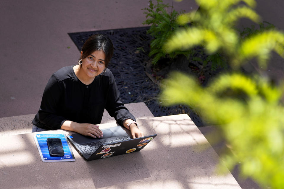 Fahima Sultani does homework on campus at Arizona State University, Friday, April 7, 2023, in Tempe, Ariz. Sultani and others tried for days in the summer of 2021 to get into the Kabul airport, only to be turned away by the gun-wielding extremists as the Taliban swept back into power. After a harrowing escape, Sultani is one of more than 60 Afghan women who arrived at ASU in December 2021. (AP Photo/Matt York)