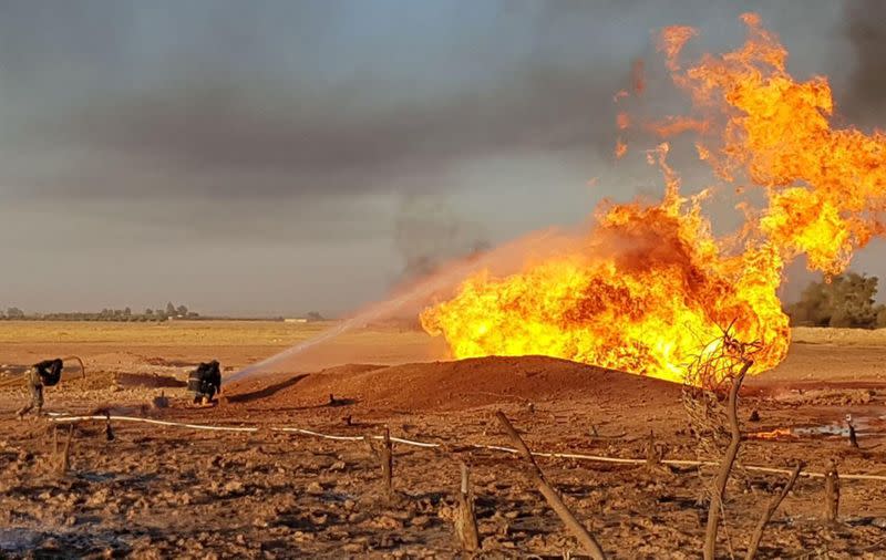 A firefighter sprays water on the fire that resulted from an explosion on the Arab Gas Pipeline between the towns of Ad Dumayr and Adra, northwest of the capital of Damascus