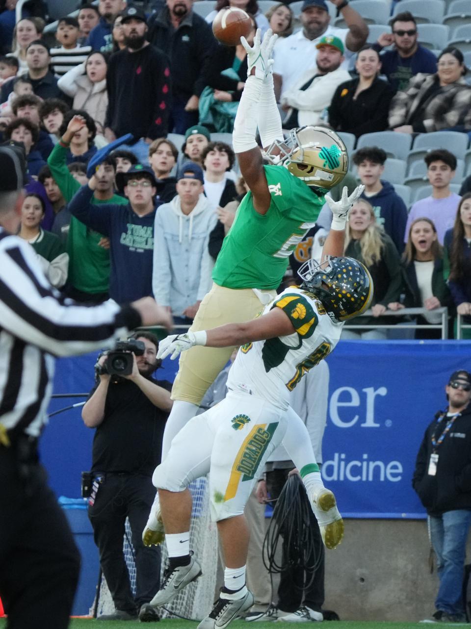 Yuma Catholic Shamrocks receiver Sir Stokes (2) catches a pass over Canyon del Oro Dorados defensive back Joe Alba (23) during their 4A State Championship game at Mountain America Stadium on Dec. 1, 2023, in Tempe.