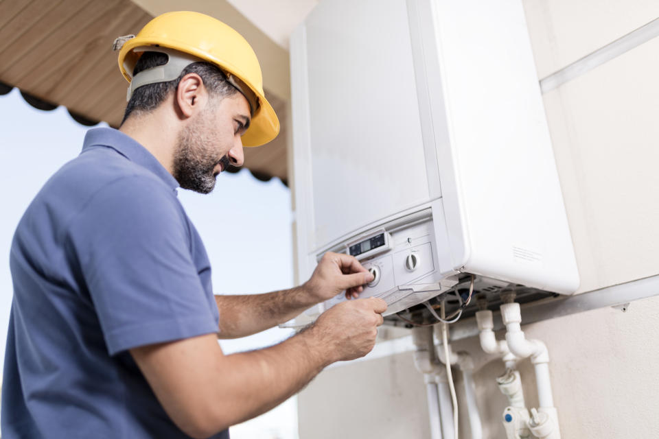 Boiler technician working in home.