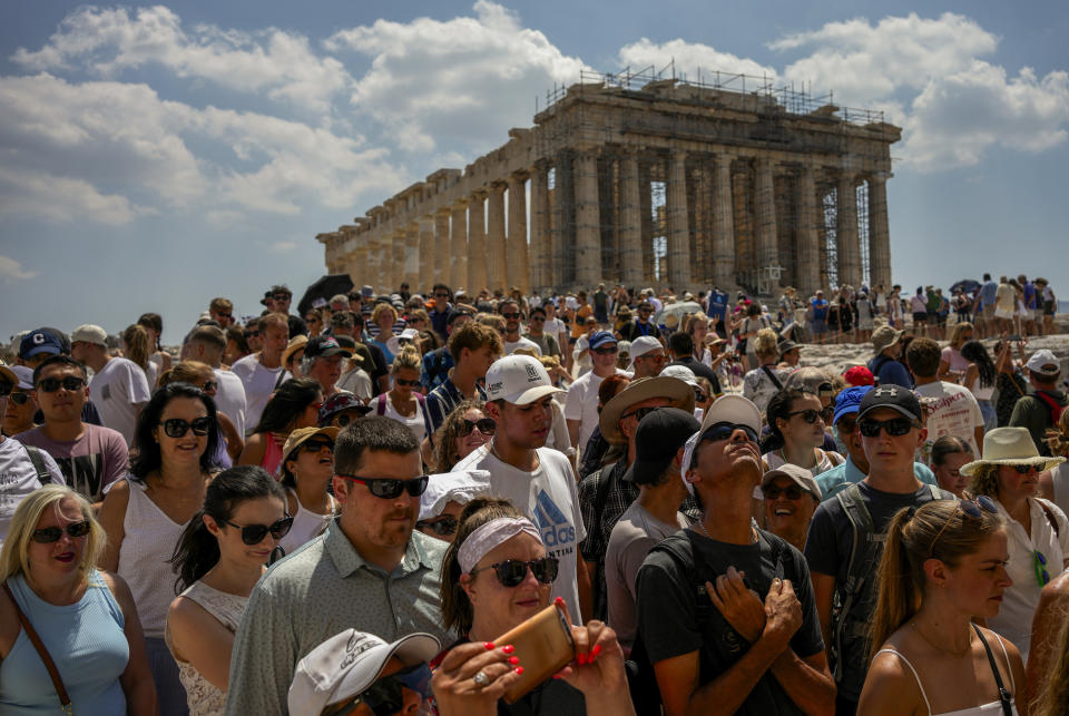 Centenares de turistas visitan el templo del Partenón en la cima de la Acrópolis, en Atenas, Grecia, el martes 4 de julio de 2023. Las multitudes colman el Coliseo, el Louvre, la Acrópolis y otras atracciones importantes este verano, mientras el turismo supera los récords de 2019 en algunos de los destinos más populares de Europa. Luego de que los europeos permitieron la recuperación del sector turístico el año pasado, el repunte de este verano es liderado en gran medida por los estadounidenses, beneficiados por un dólar fuerte y, en algunos casos, por sus ahorros durante la pandemia. (AP Foto/Thanassis Stavrakis)