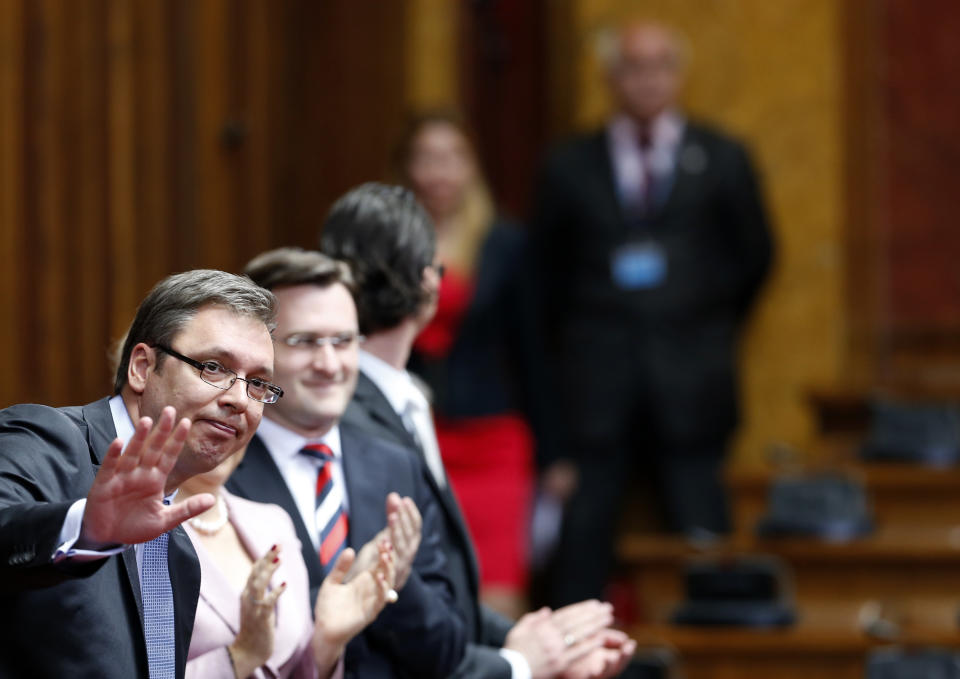 Serbian Prime Minister designate Aleksandar Vucic, left, waves in the parliament, in Belgrade, Serbia, Sunday, April 27, 2014. Vucic announced that his government would be formed on Sunday. (AP Photo/Darko Vojinovic)