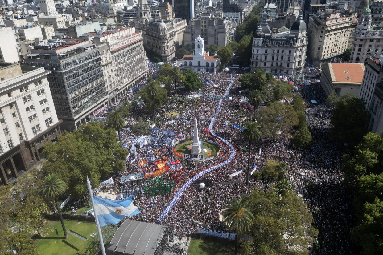 Des centaines de personnes tiennent une grande banderole avec des portraits de personnes disparues pendant la dictature militaire (1976-1983), à Buenos Aires, le 24 mars 2023.