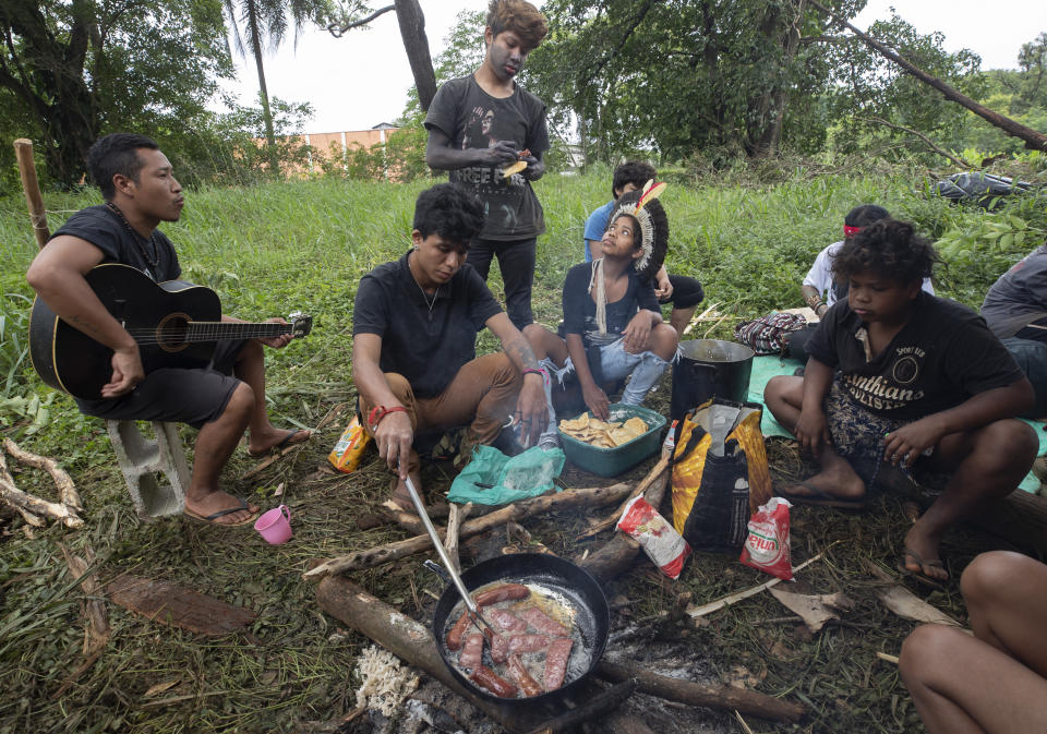 Guarani Mbya protesters cook a meal on property being prepared by real estate developer Tenda, which plans to build apartment buildings, next to their indigenous community's land in Sao Paulo, Brazil, Friday, Jan. 31, 2020. The tension between a builder with projects in nine Brazilian states and a 40-family indigenous community is a microcosm of what’s playing out elsewhere in the country. (AP Photo/Andre Penner)