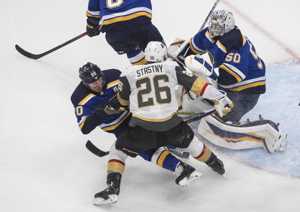 St. Louis Blues' Alexander Steen (20) is checked by Vegas Golden Knights' Paul Stastny (26) as Blues goalie Jordan Binnington (50) looks for the puck during the second period of an NHL hockey playoff game Thursday, Aug. 6, 2020, in Edmonton, Alberta. (Jason Franson/Canadian Press via AP)