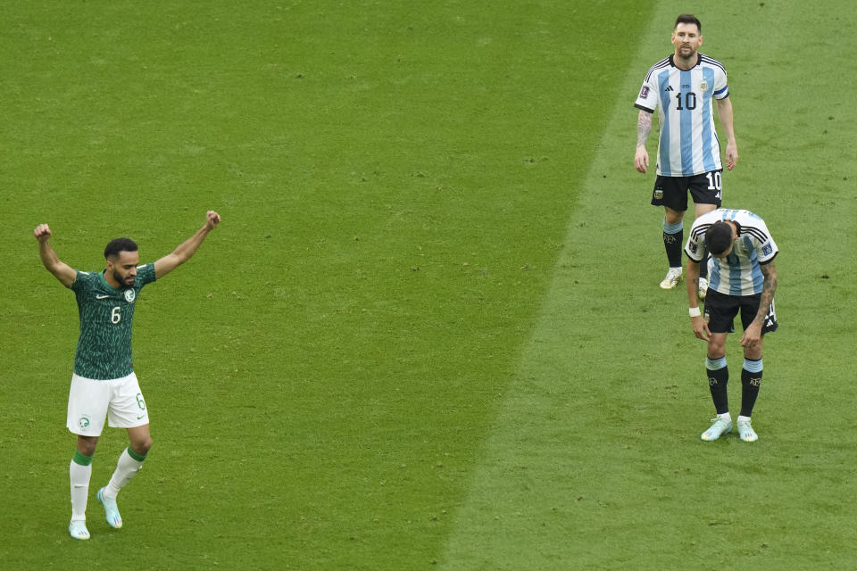 Argentina's Lionel Messi, top right, leaves the pitch as Saudi Arabia's Mohammed Al-Burayk celebrates after his team's win in the World Cup group C soccer match between Argentina and Saudi Arabia at the Lusail Stadium in Lusail, Qatar, Tuesday, Nov. 22, 2022. (AP Photo/Luca Bruno)