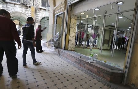 Workers in a shop replace the glass after it was damaged following a blast in central Cairo February 3, 2015. REUTERS/Mohamed Abd El Ghany