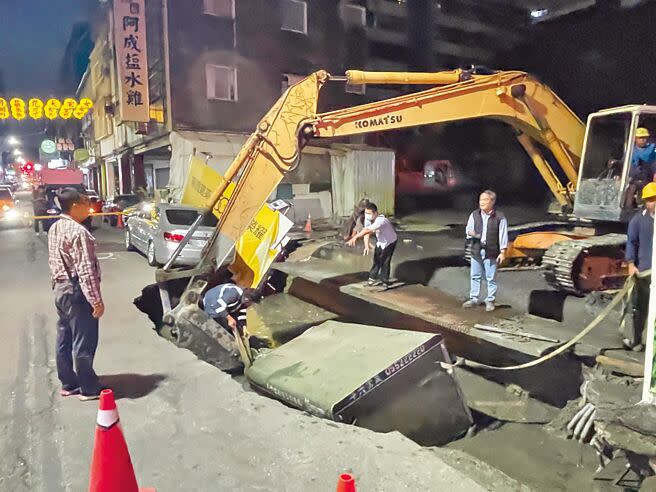 台南市西門路與五妃街口一處新建大樓工地，6日下午突發生工地旁路面塌陷，一部小貨車掉落坑洞中，圖為施工單位設法將車吊起。（寶智華攝）